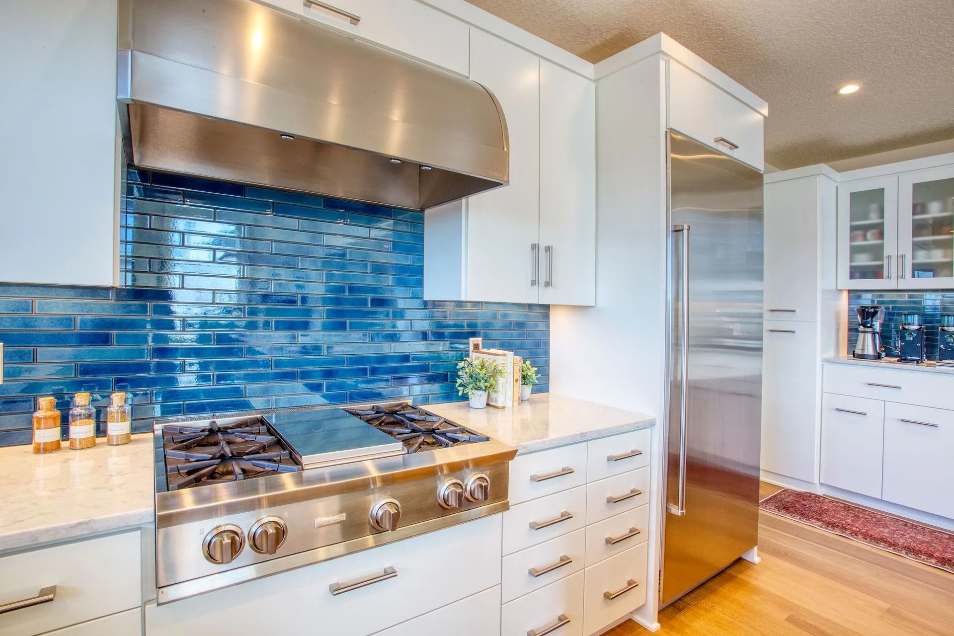 Sleek kitchen featuring gas stove and fridge