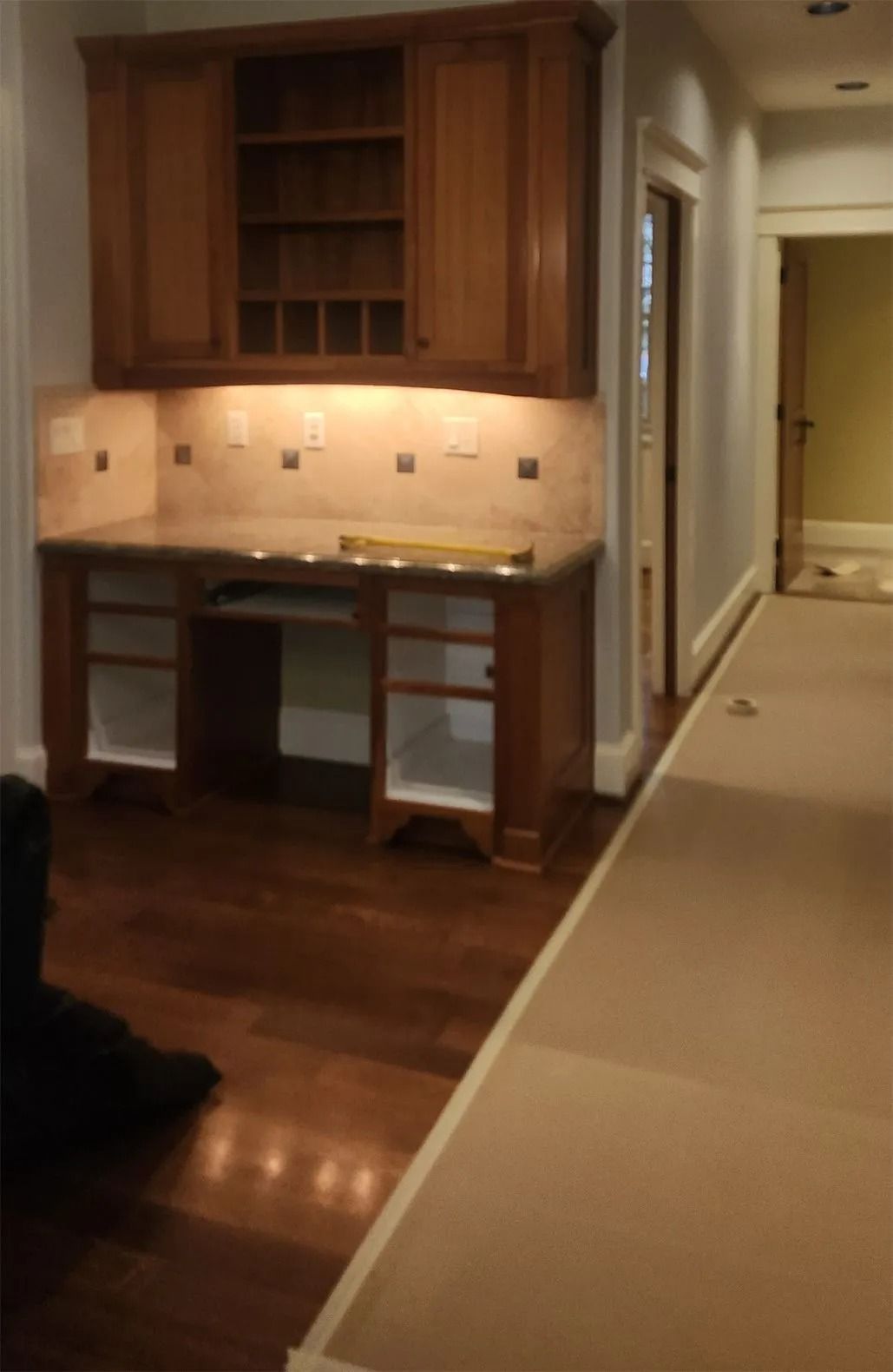 Hallway with wooden cabinetry and counter