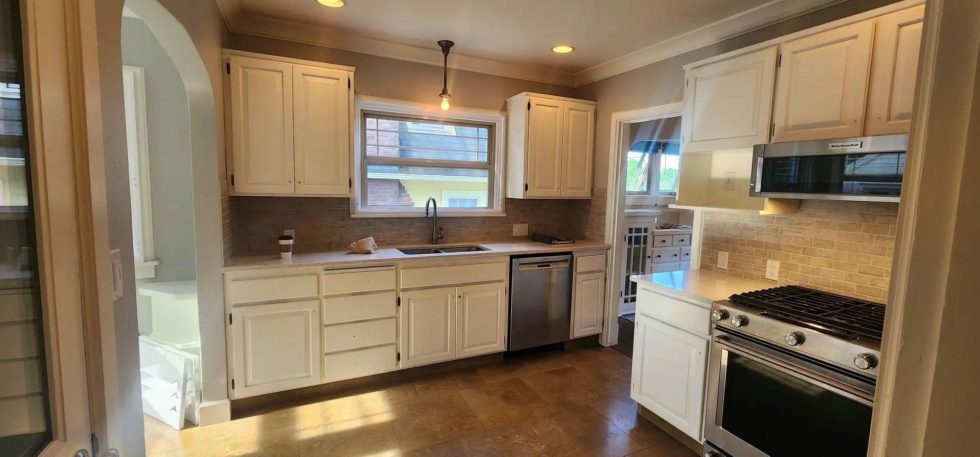 Sunlit kitchen interior with arched doorway