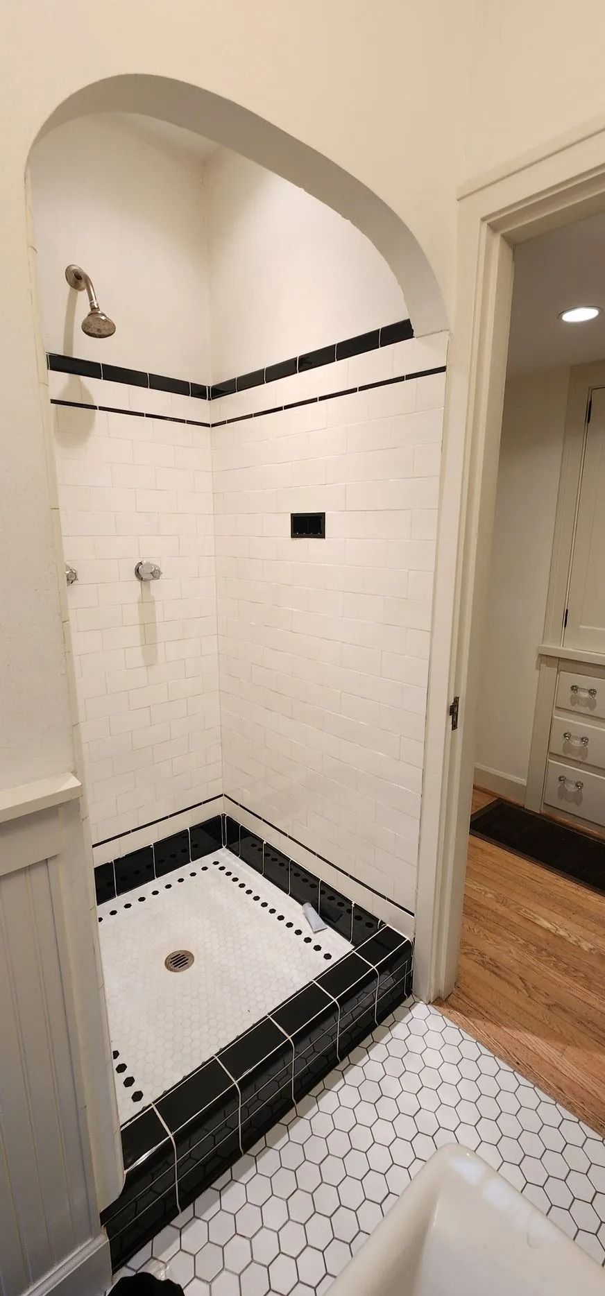 White tiled shower with black accents