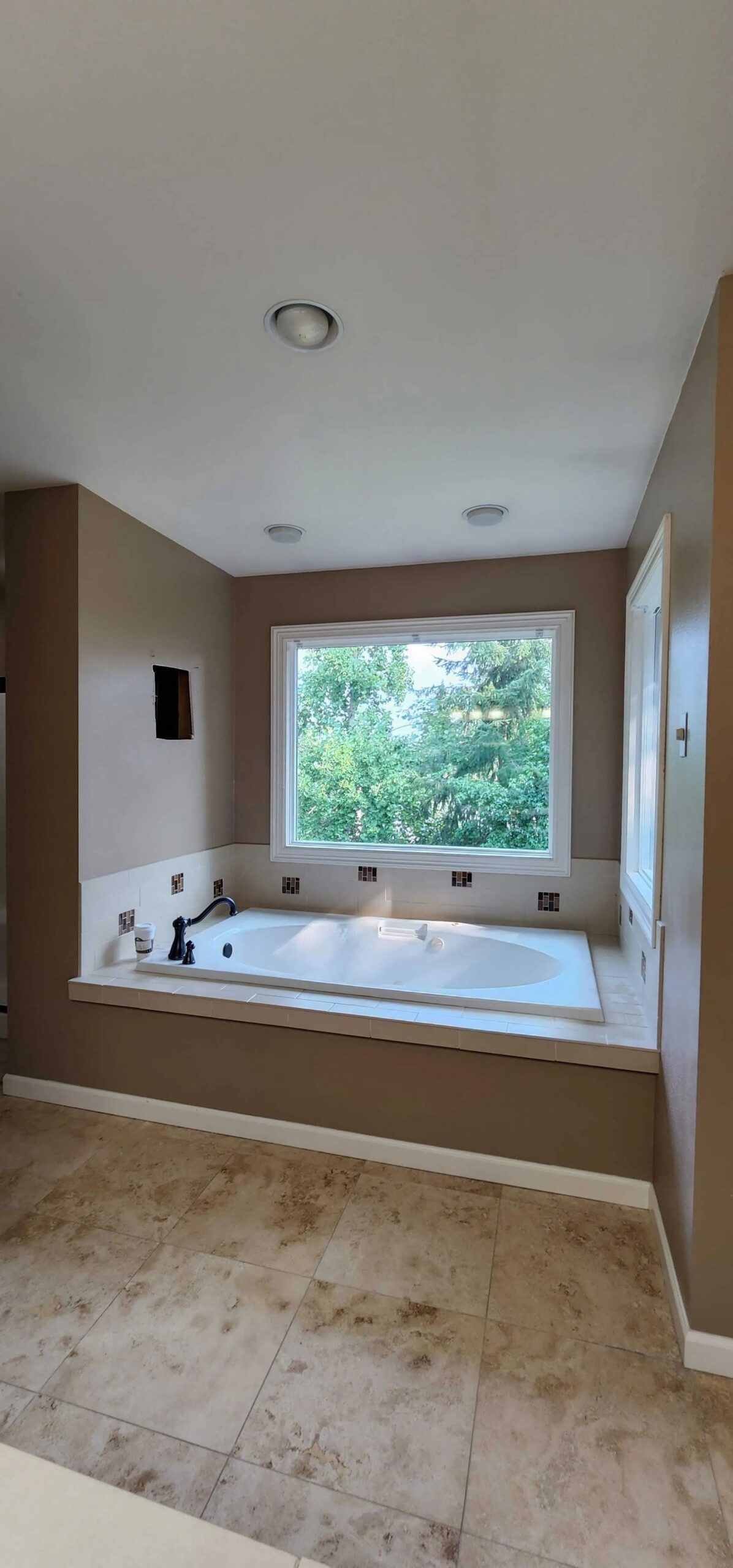 Spacious bathroom featuring corner bathtub.