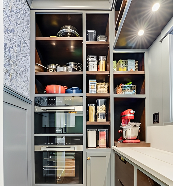 Modern kitchen pantry with appliances and shelves.