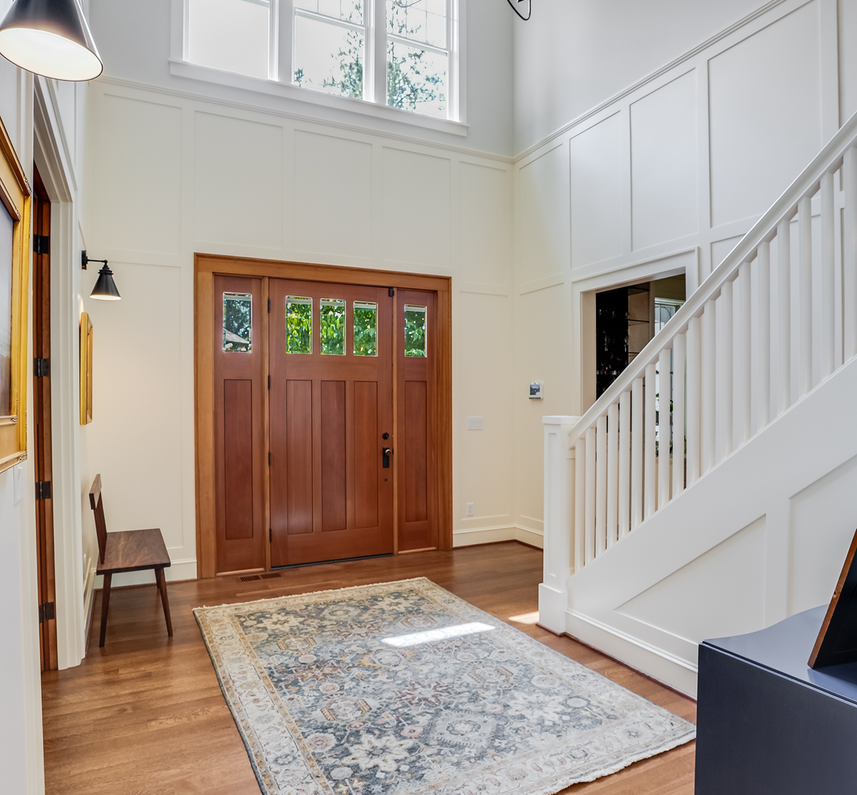 Sunlit entryway with wooden door and staircase