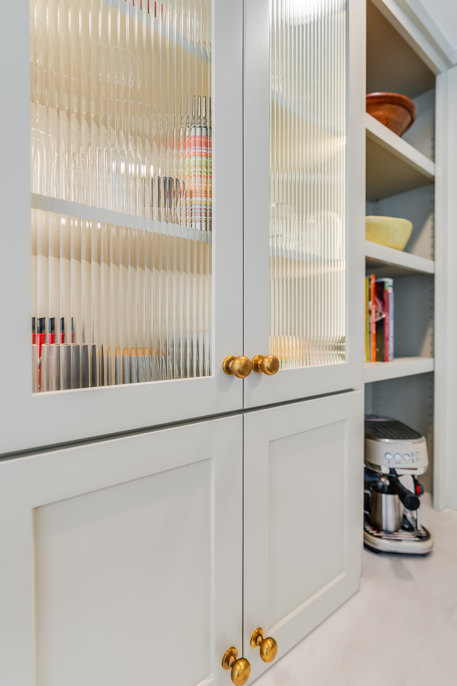 White kitchen cabinets with fluted glass, brass knobs