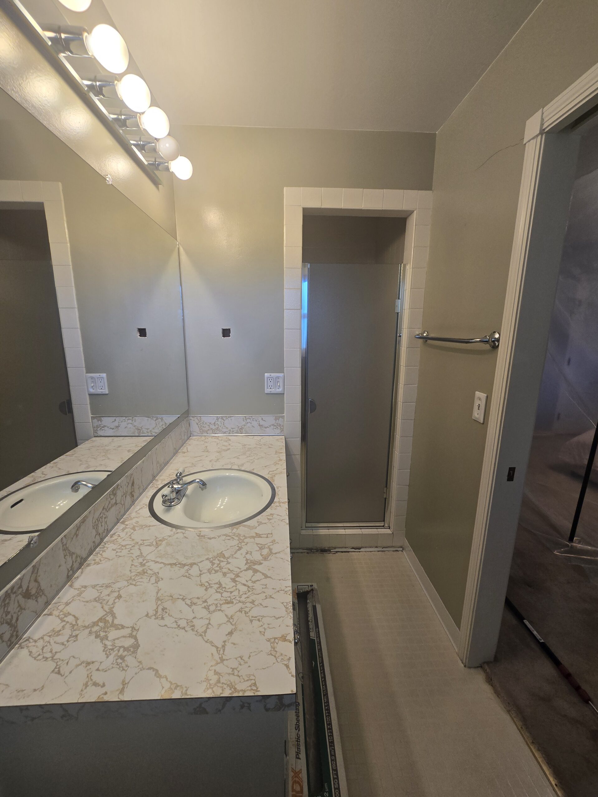 Bathroom vanity with sink, mirror, and shower