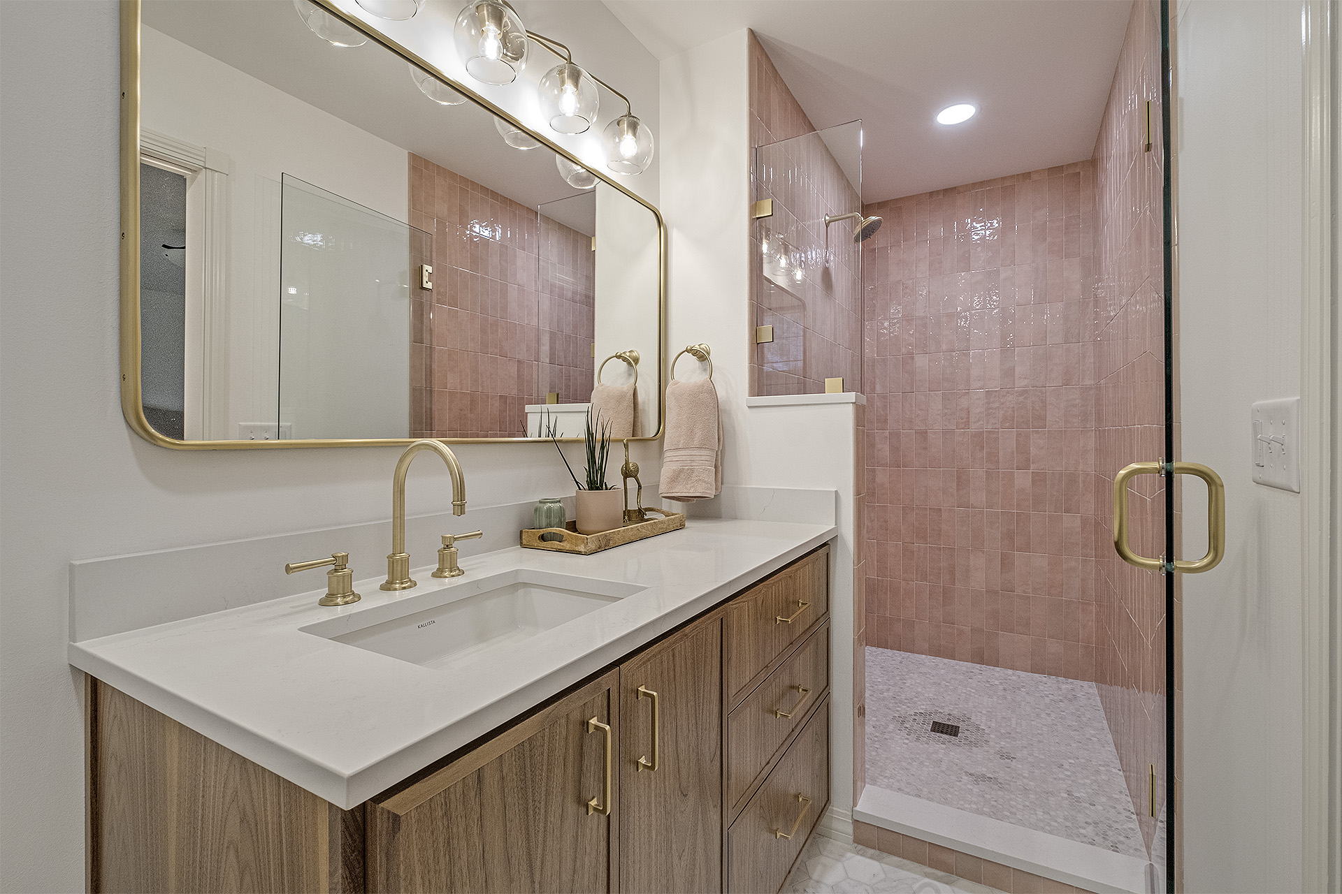 Bathroom vanity with pink-tiled shower