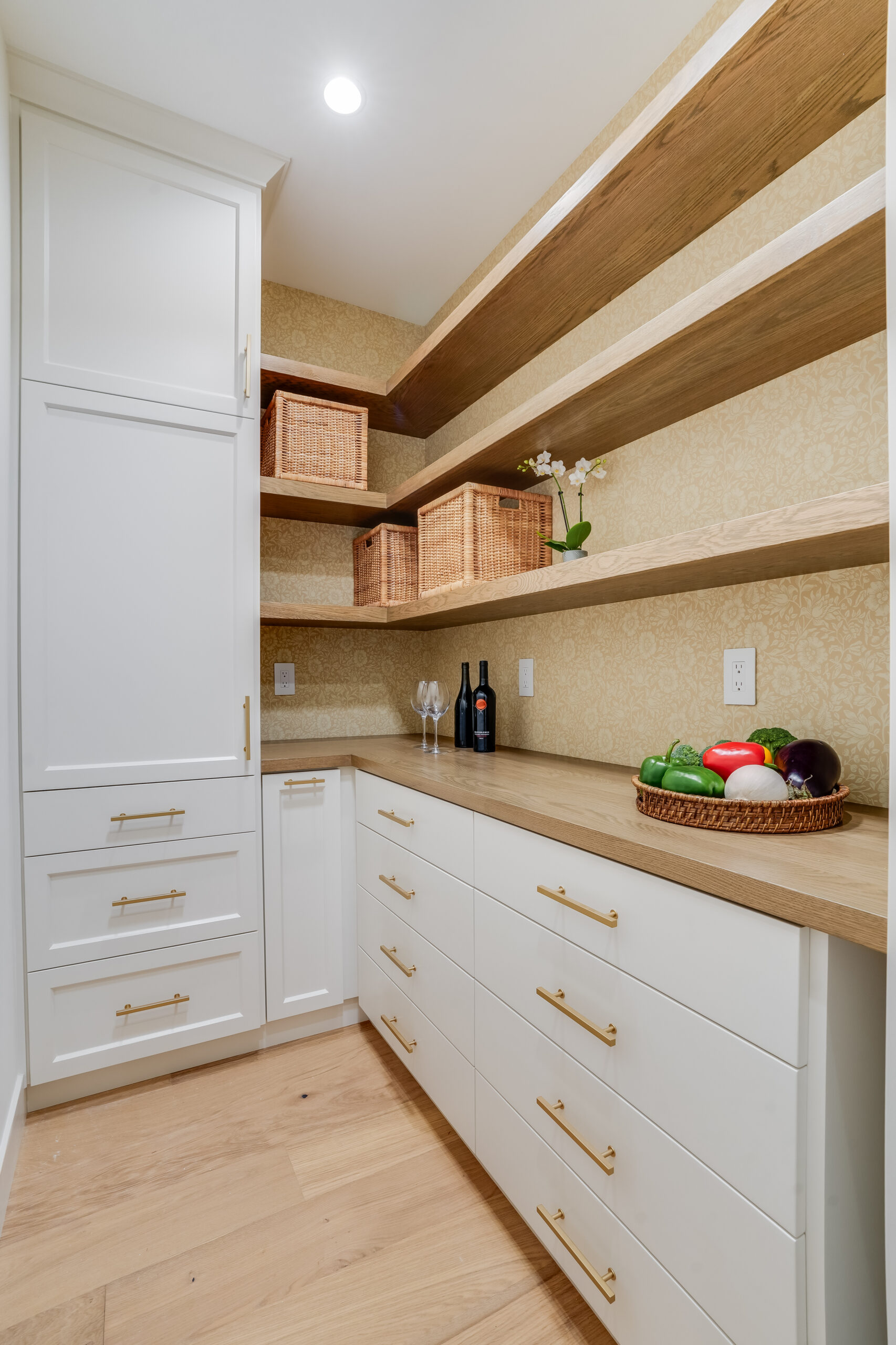 Pantry with white cabinets and wooden shelves